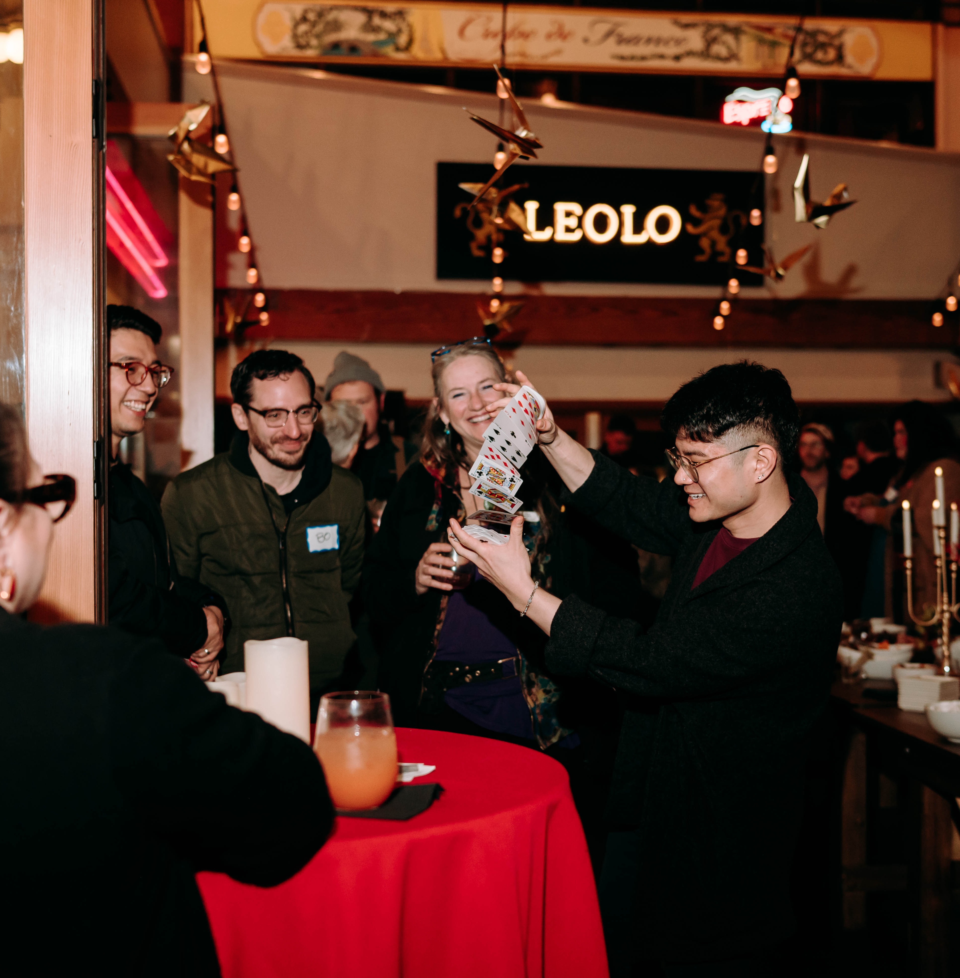 Travis Kim performing at Pike Place with cascading cards and guests reacting behind him.